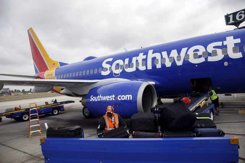 A ground operations employee loads luggage onto a Southwest Airlines Boeing 737 on the...