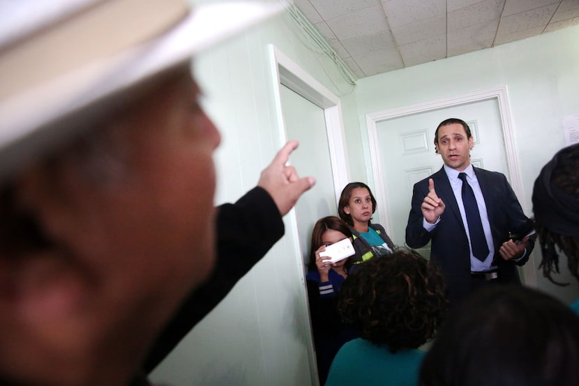 HMK landlord Khraish Khraish (right) speaks back and forth with tenant Joe Garcia during a...