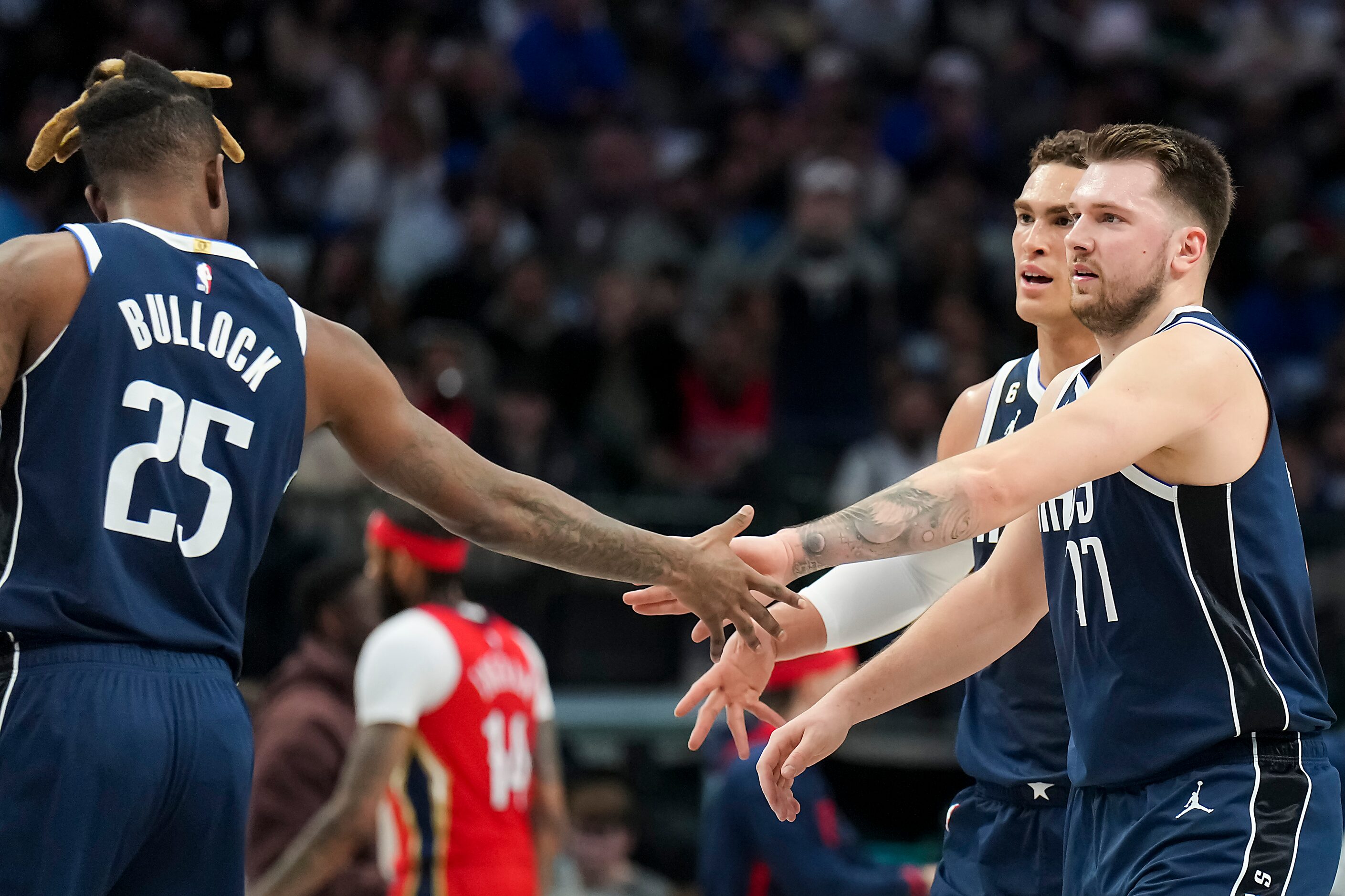 Dallas Mavericks guard Luka Doncic (77) celebrates with forward Reggie Bullock (25) after a...