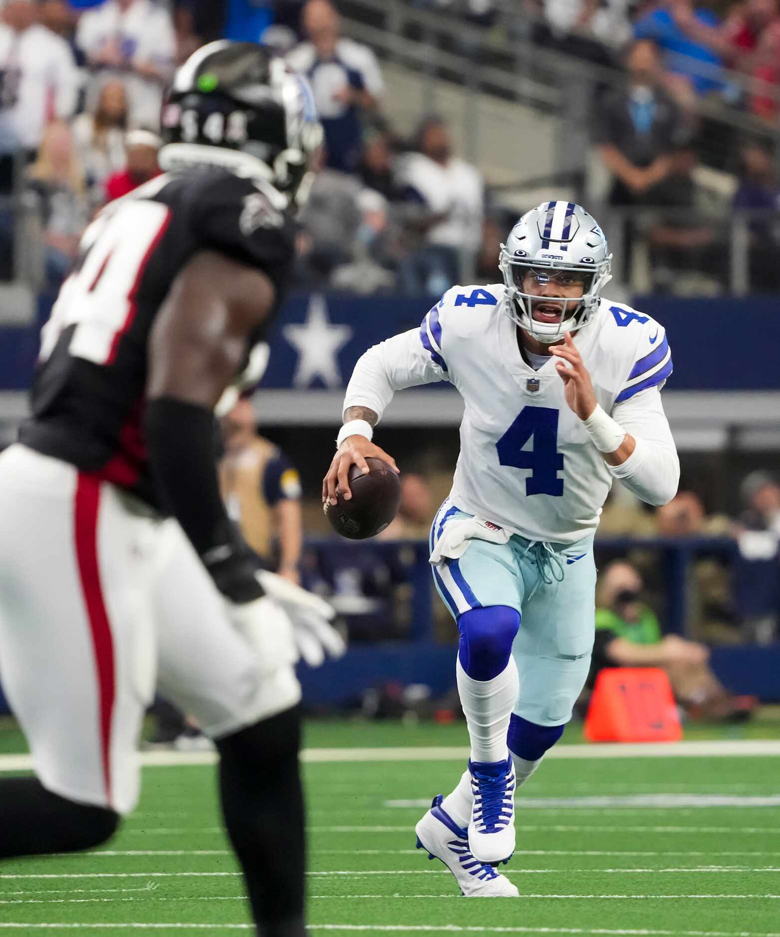 Dallas Cowboys quarterback Dak Prescott (4) scrambles on a fourth down play before throwing...