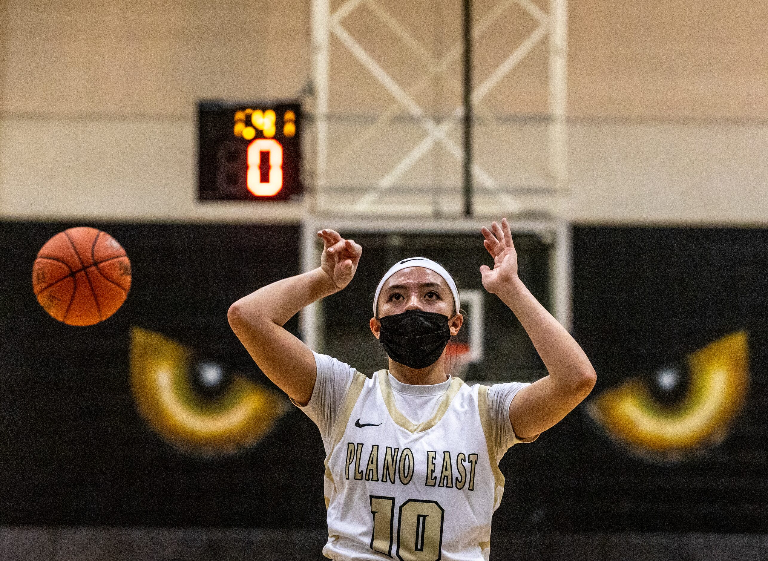 Plano East High School Kaitlyn Hong (10) follows through after shooting while a basketball...