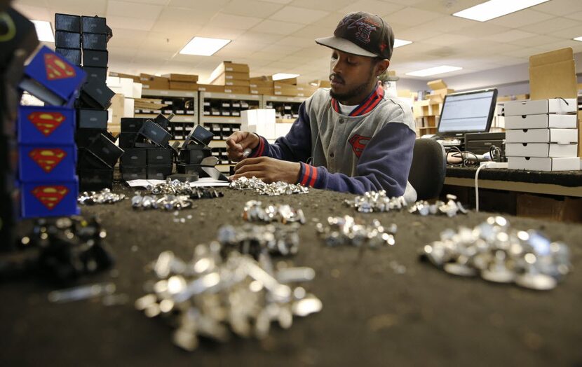 Brandon Yeates fills orders of cufflinks in the shipping and receiving at Cufflinks.com on...