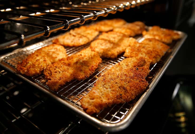 Cooked chicken breasts are placed in the preheated oven.