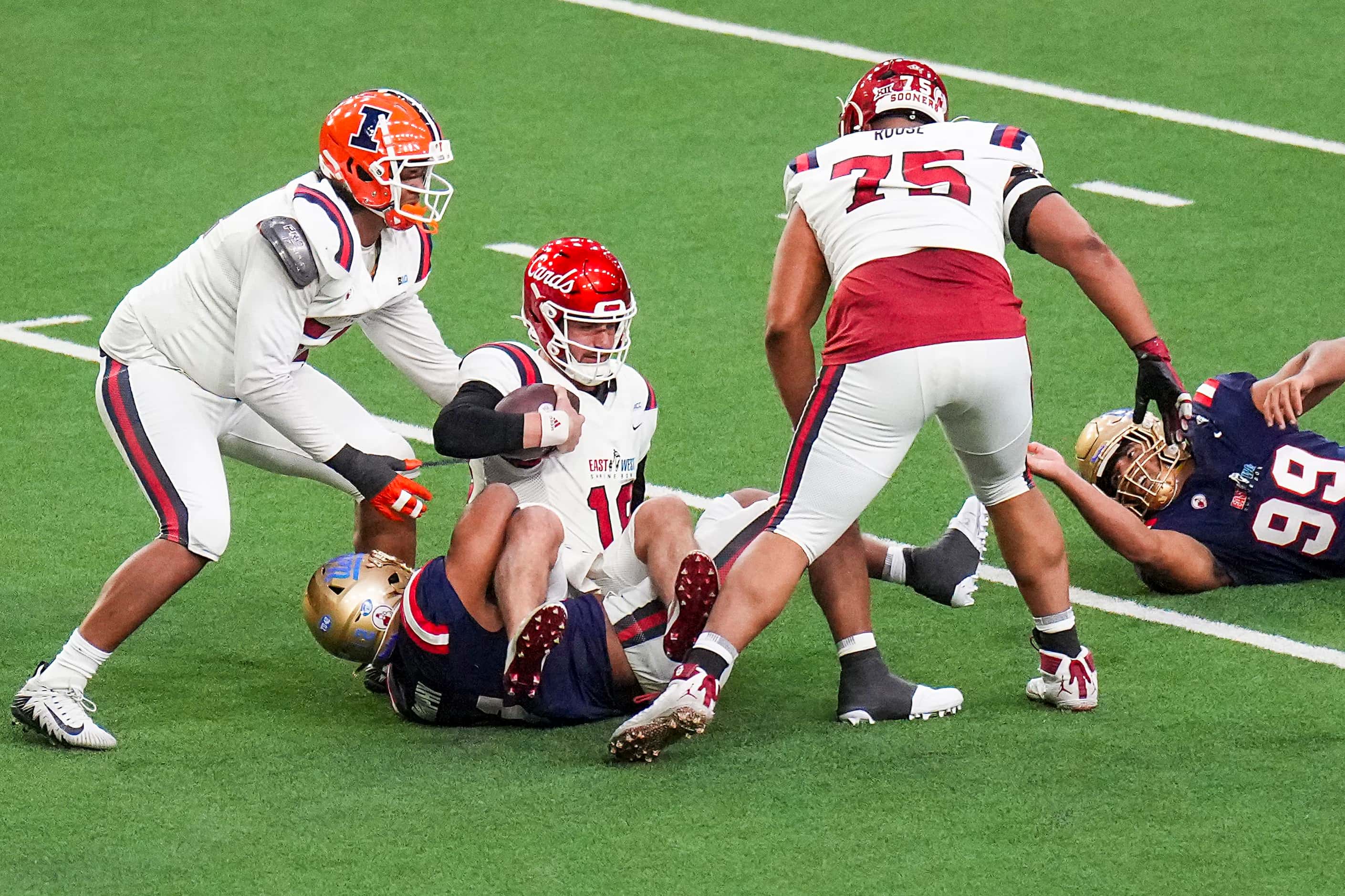 East quaterback Jack Plummer of Louisville (18) is sacked by West defensive lineman  Grayson...