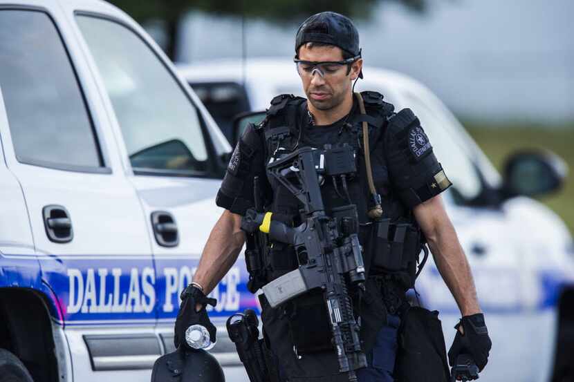  A Dallas SWAT officer who did not want to be identified by name walks to his vehicle at the...