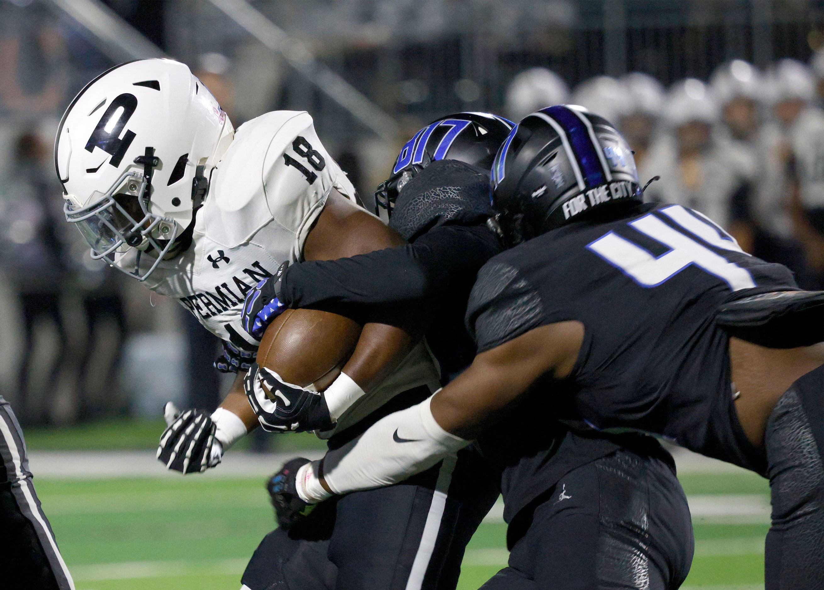 Permian's Gavin Black (18) is tackled by North Crowley's Avery Dotson (32).center, and North...