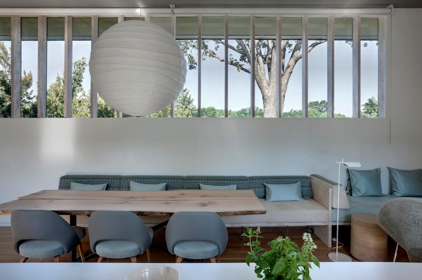 
A rice-paper Noguchi pendant lamp hangs above a white oak dining table off the home’s...