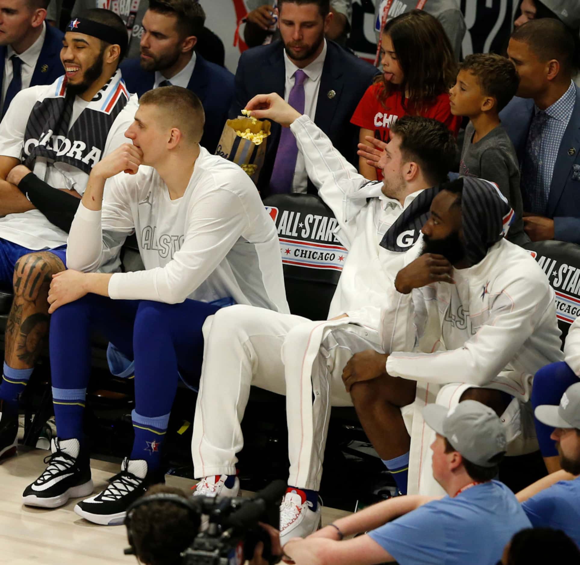 Team LeBron's Luka Doncic (2) gets a handful of Garrett's popcorn on the bench during the...