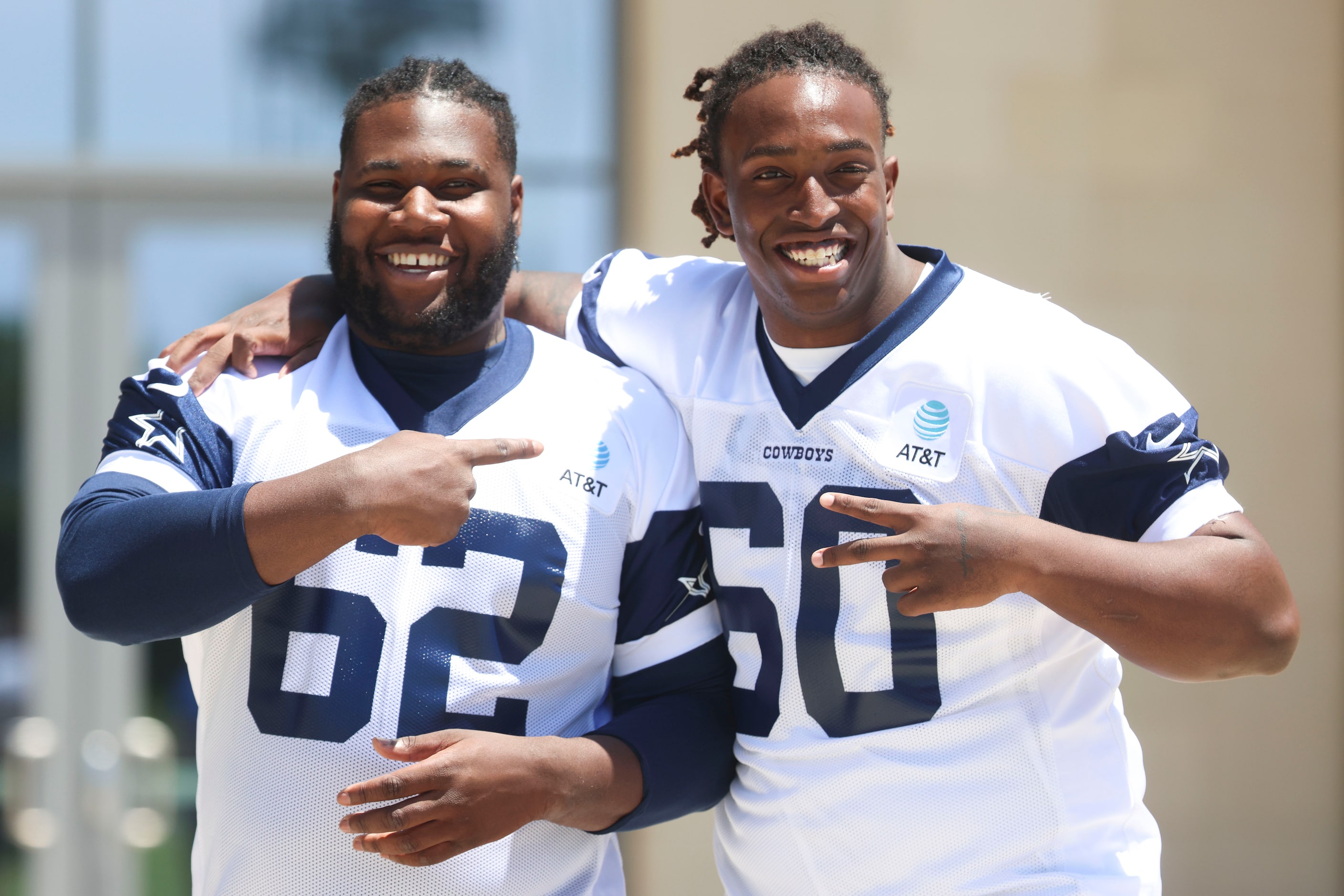 Dallas Cowboys offensive line Nathan Thomas (62) and Tyler Guyton (60) share a laugh as they...