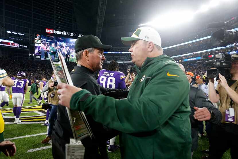 Minnesota Vikings head coach Mike Zimmer, left, talks with Green Bay Packers head coach Mike...