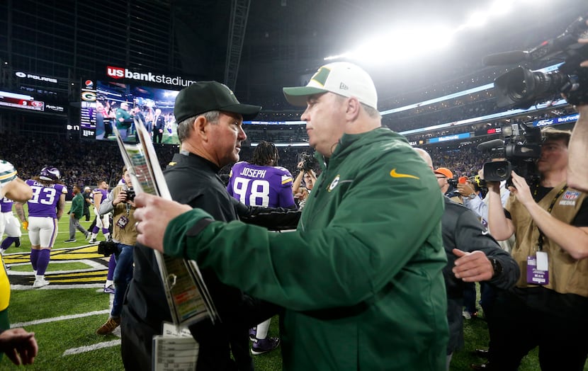 Minnesota Vikings head coach Mike Zimmer, left, talks with Green Bay Packers head coach Mike...