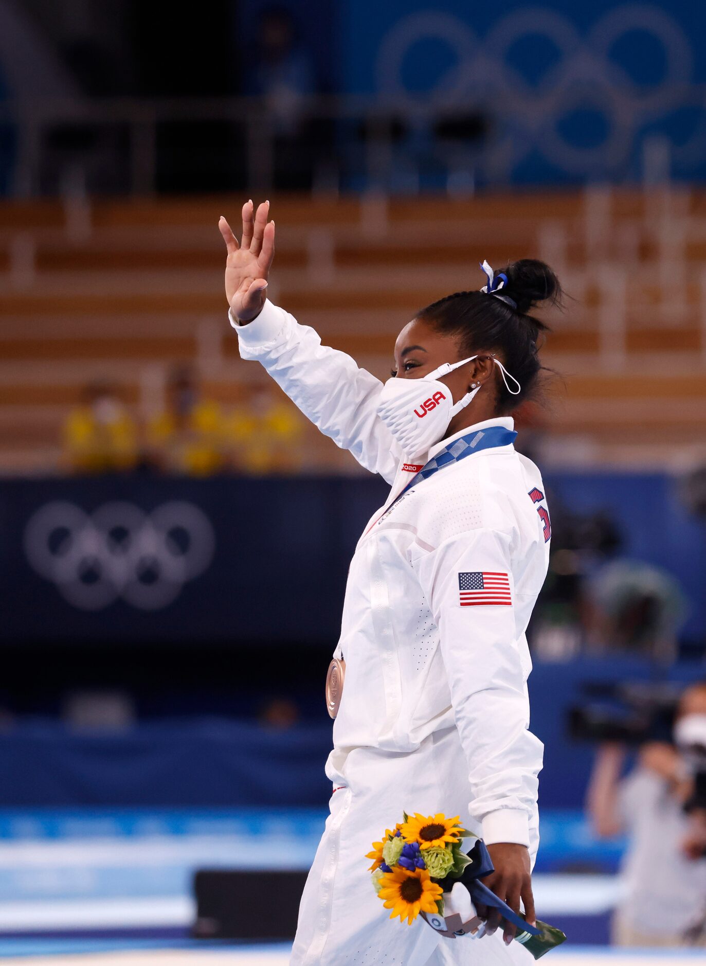 USA’s Simone Biles walks around the stage with her bronze medal during the medal ceremony...