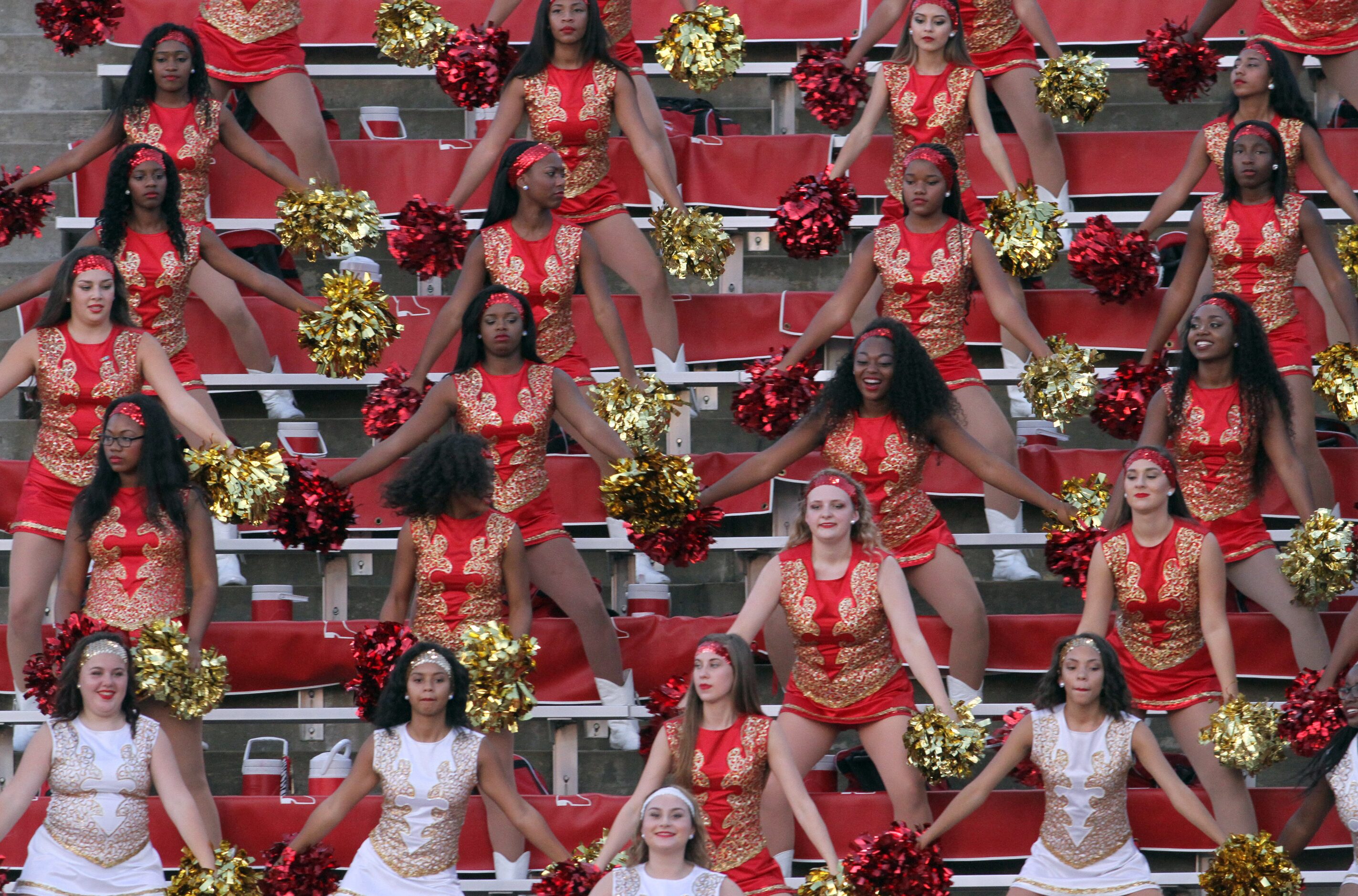 Members of the South Grand Prairie Warriors drill team dance to the band's music during the...