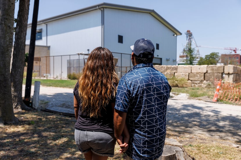 Alma Aragonez (left) holds hands with her husband Eddie Aragonez as they look across the...