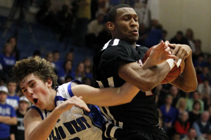 Flower Mound Marcus's Nick Banyard (4) grabs a rebound in front of  Plano West's TJ Cline...