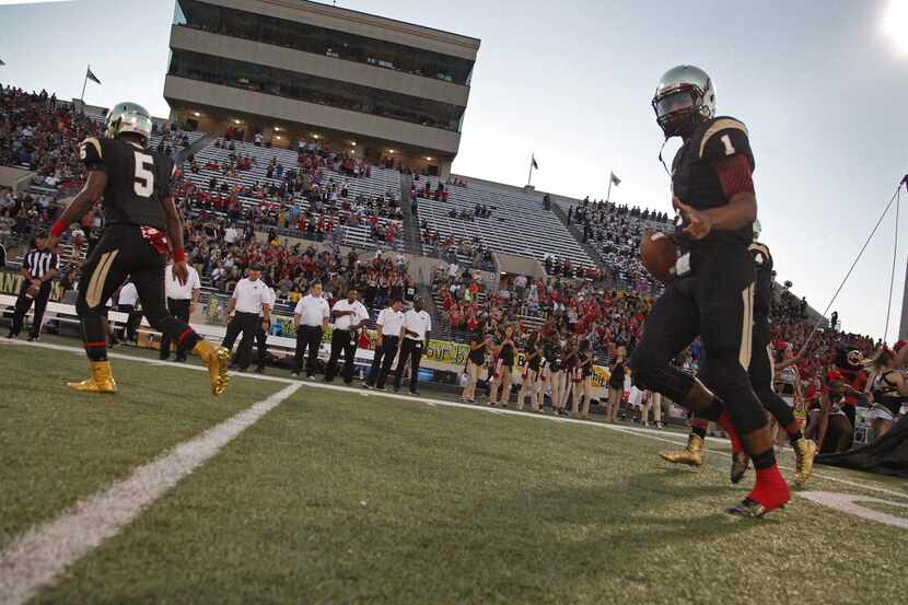 Plano East quarterback Miklo Smalls (1) takes the field before kickoff as Plano East High...