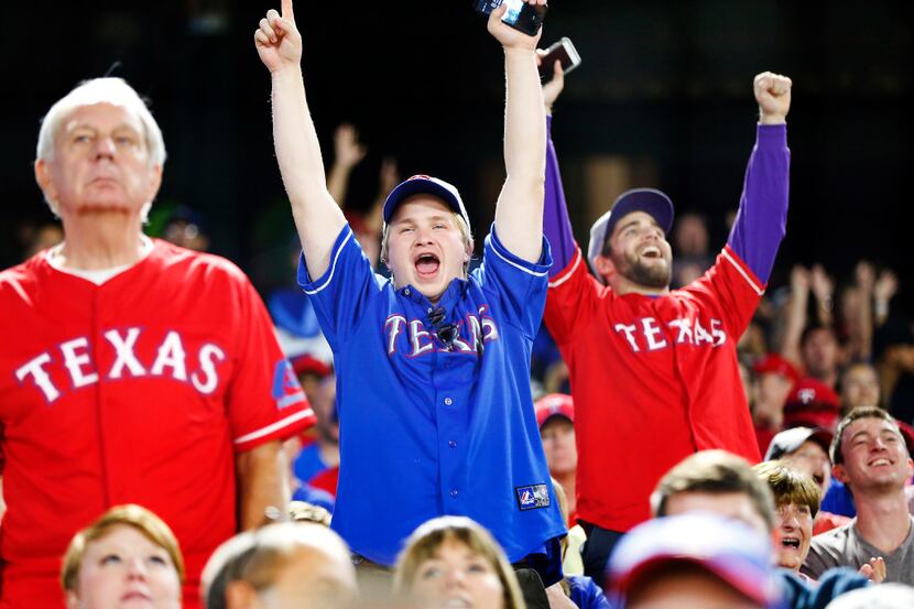 Texas Rangers fans celebrate the winner of the Dot Race during the sixth inning at Globe...