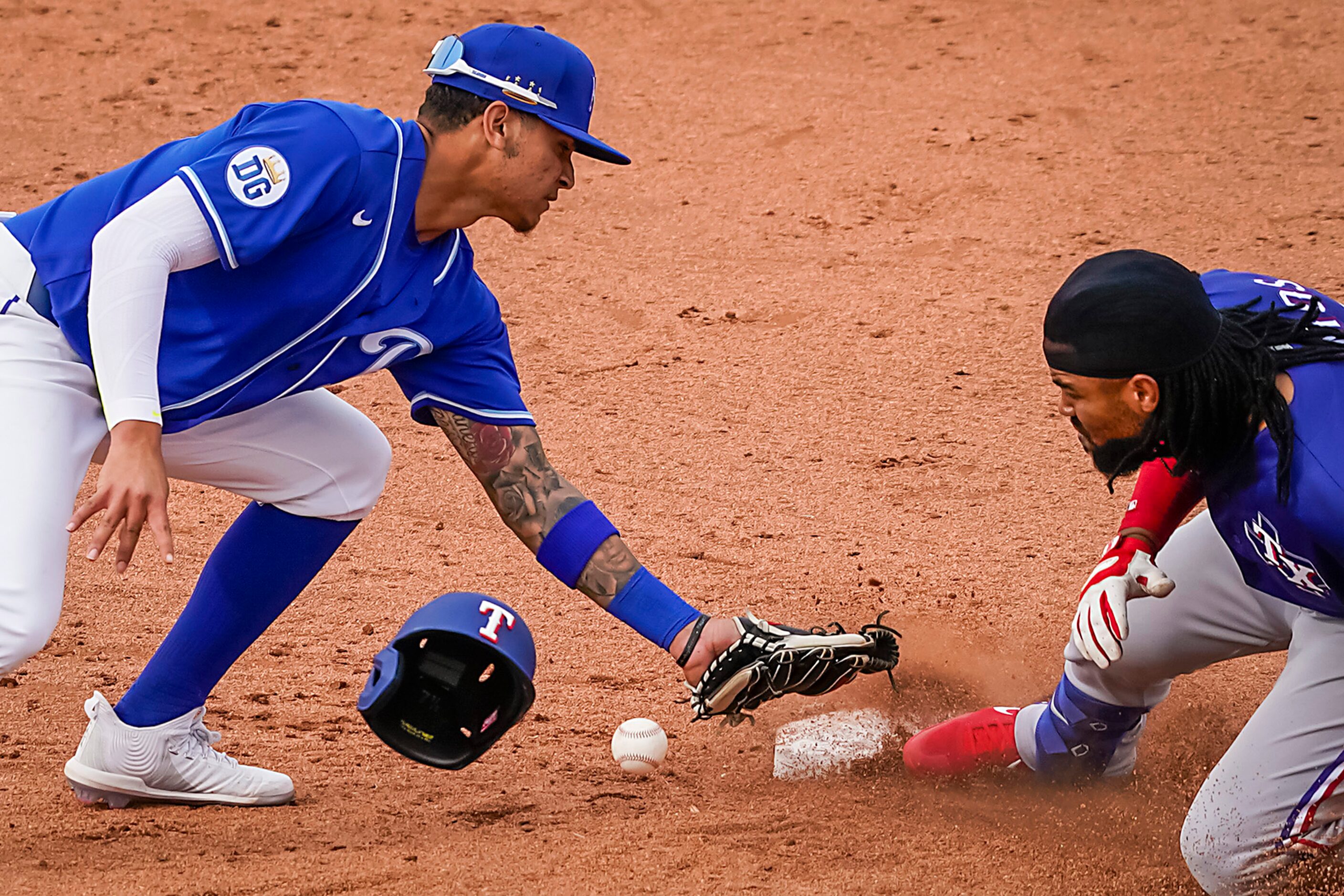 Texas Rangers outfielder Henry Ramos is safe at second base as the ball gets away from...