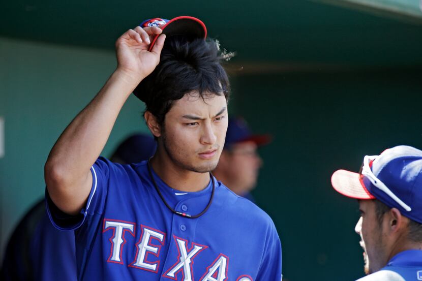 Texas Rangers starting pitcher Yu Darvish talks with outfielder Hirotoshi Onaka in the...