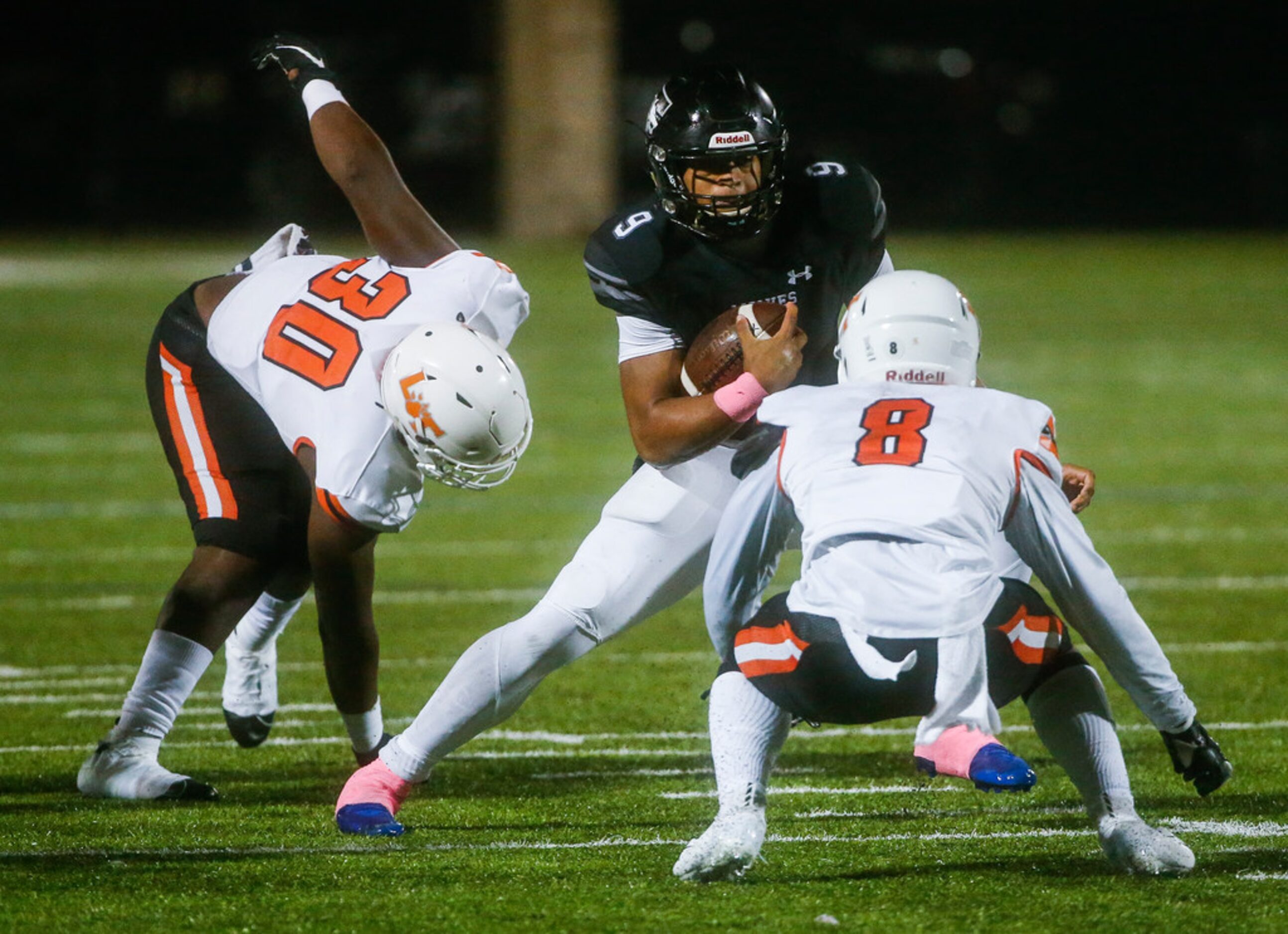 Mansfield Timberview's Jaden Hullaby (9) works to break away from Lancaster's Waymon Smith...