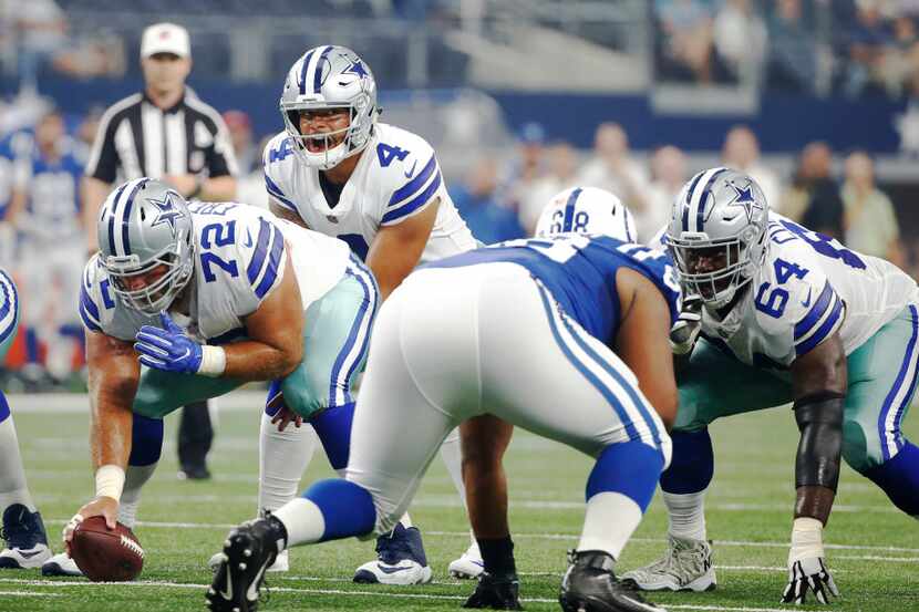 Dallas Cowboys quarterback Dak Prescott (4) before the snap by Dallas Cowboys center Travis...
