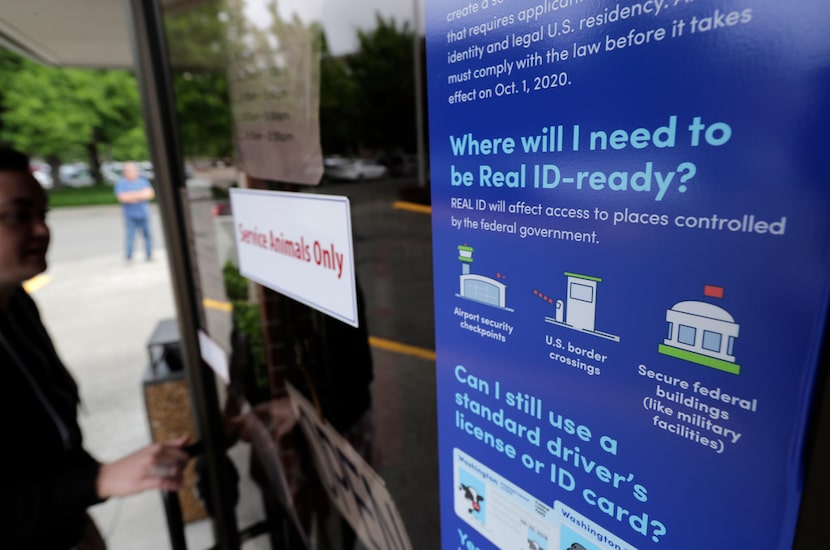 A customer opens the door of a Washington state Dept. of Licensing office in Lacey, Wash.,...