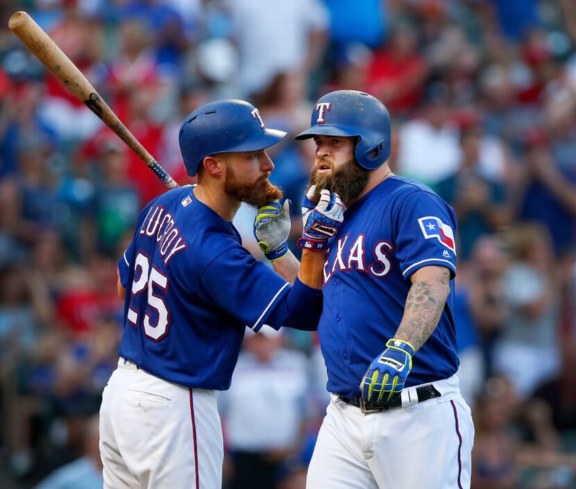 Texas Rangers Mike Napoli (right) and teammate Jonathan Lucroy (25) pull on each others...