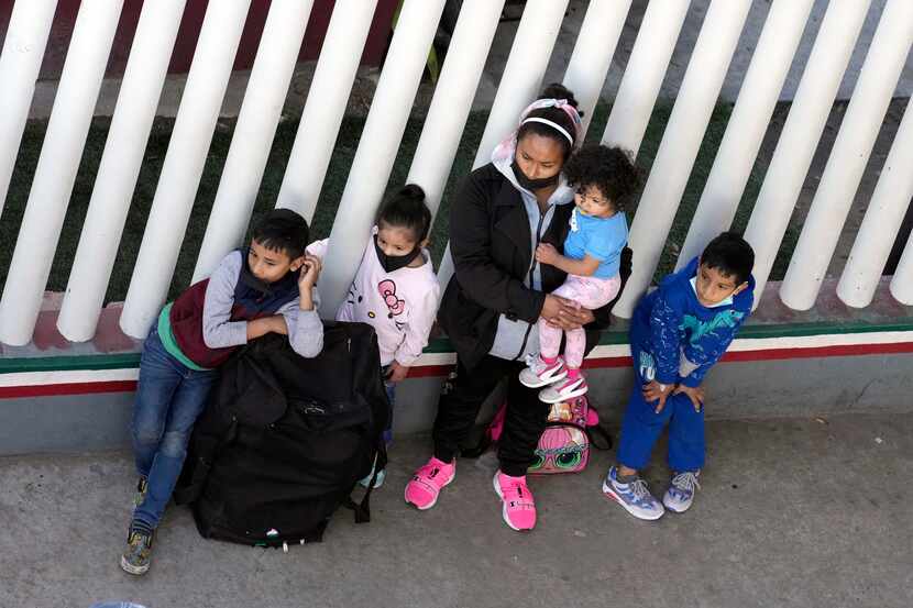 A migrant family waits with their luggage at a entry point for asylum seekers Wednesday,...