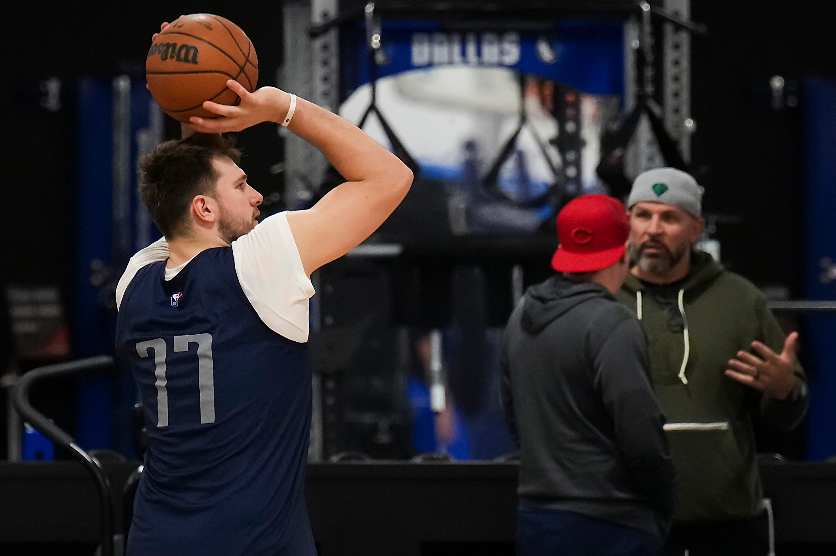 Dallas Mavericks guard Luka Doncic (77) shoots as head coach Jason Kidd (facing) talks with...