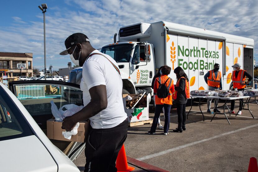 Frank MacArryer places cases of produce and beans into his car he received from a North...