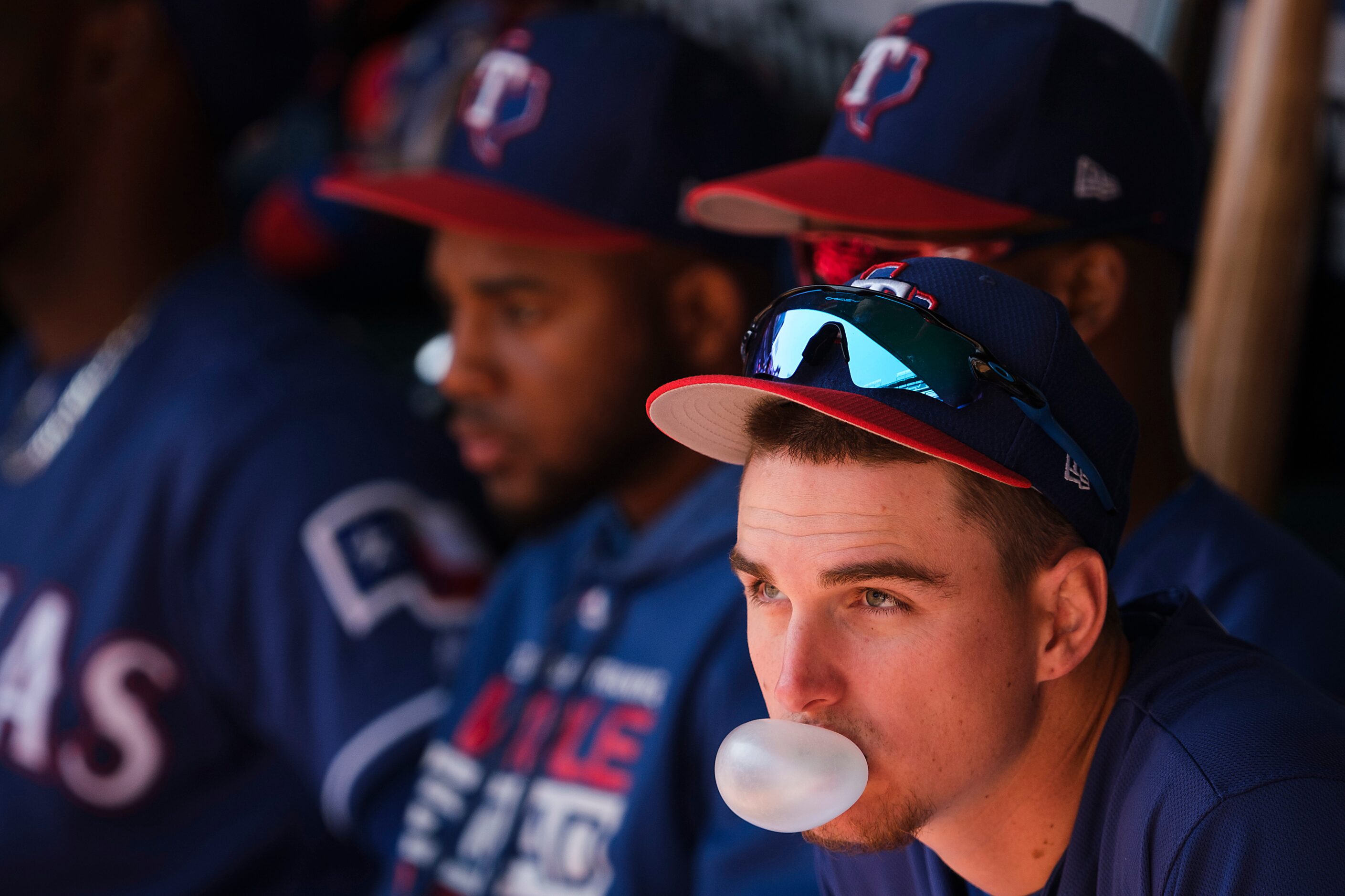 Texas Rangers outfielder Carlos Tocci blows bubbles in the dugout before a spring training...