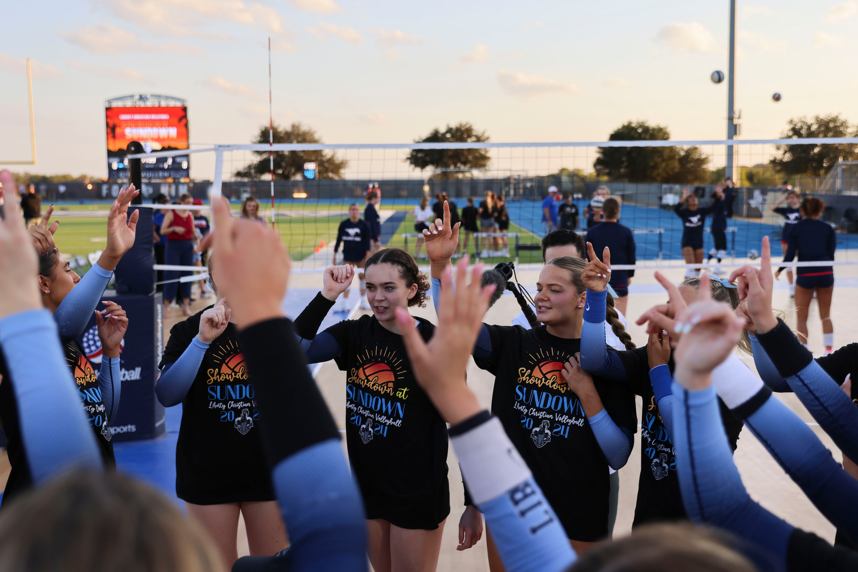 Liberty Christian School players cheer following a tea huddle ahead of an outdoor volleyball...