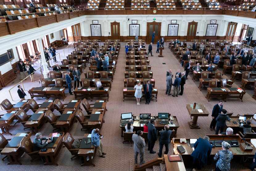 Texas House members mill about the chamber during the 2021 legislative session.