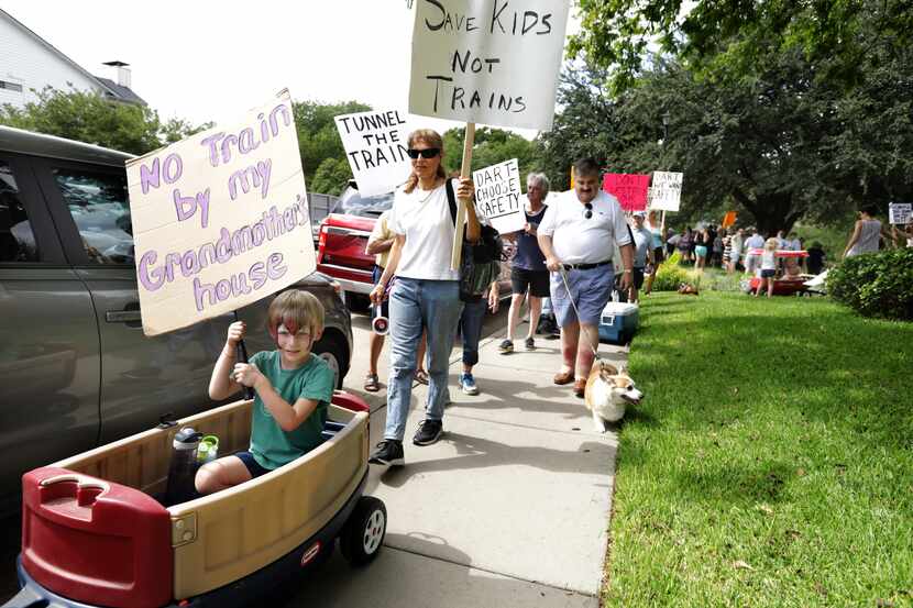 Area residents protest DART's proposed Cotton Belt Line plans as they walk along the Preston...