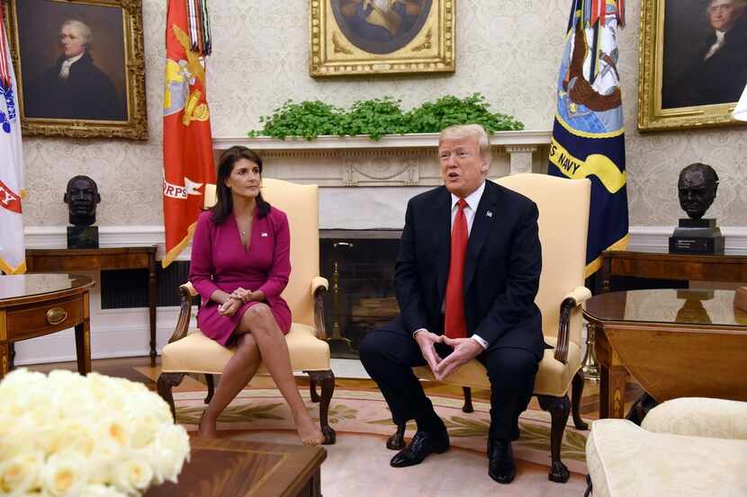President Donald Trump speaks as Nikki Haley, ambassador to the United Nations, looks on at...