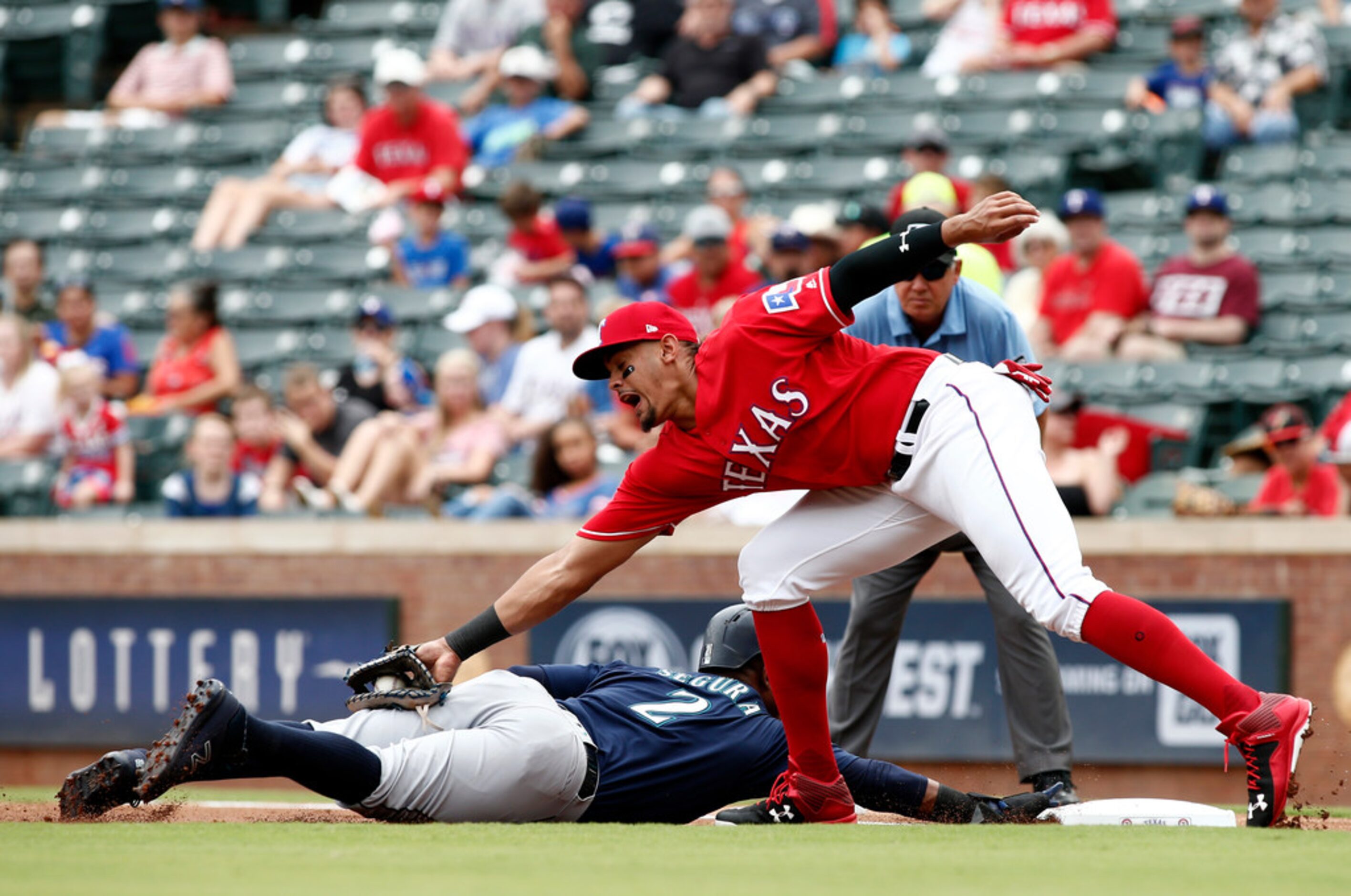 Texas Rangers first baseman Ronald Guzman is unable to make the tag on a pick-off attempt as...