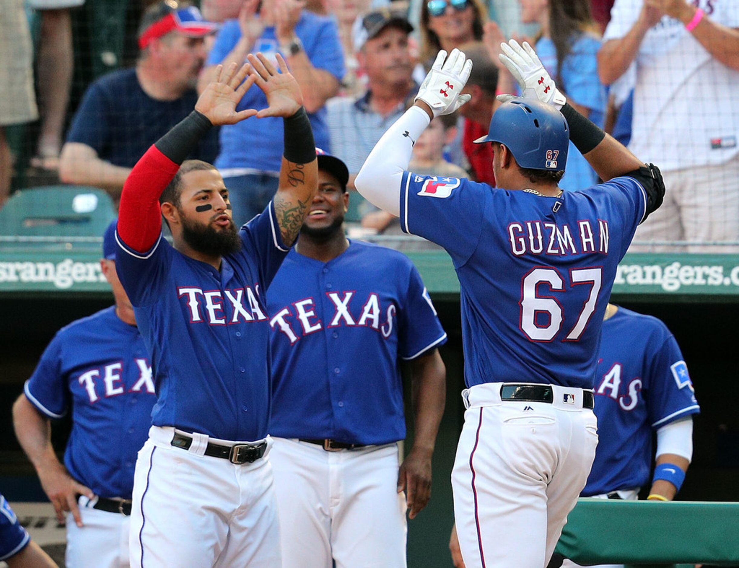 ARLINGTON, TX - MAY 23:  Rougned Odor #12 of the Texas Rangers greets Ronald Guzman #67 of...