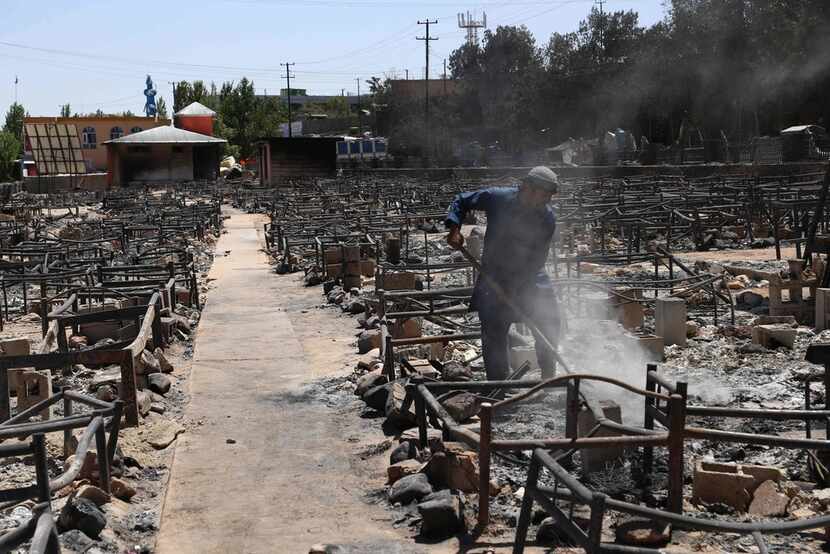 In this file photo taken on Aug. 15, 2018 an Afghan man shovels debris after Taliban...