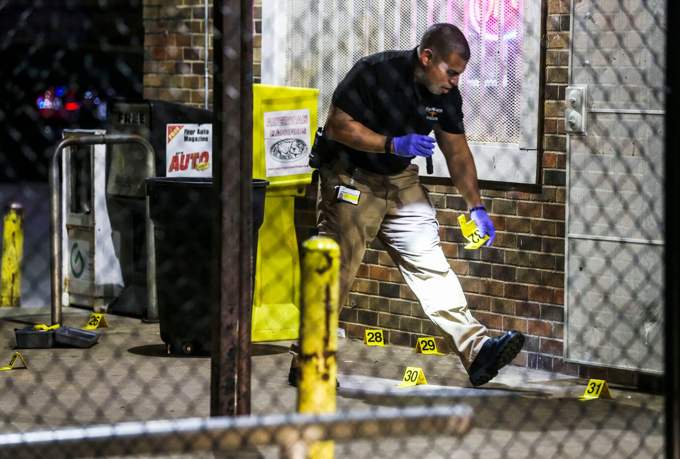 Fort Worth police officers investigate the scene of a shooting at Smokey's Paradise Food...