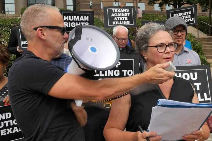 
Todd Whitley held a bullhorn microphone for Susybelle Gosslee as death penalty opponents...