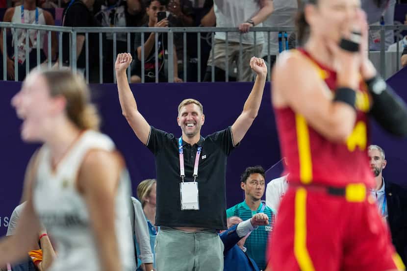 Dallas Mavericks great Dirk Nowitzki cheers a victory by Germany (in white) over Spain for...