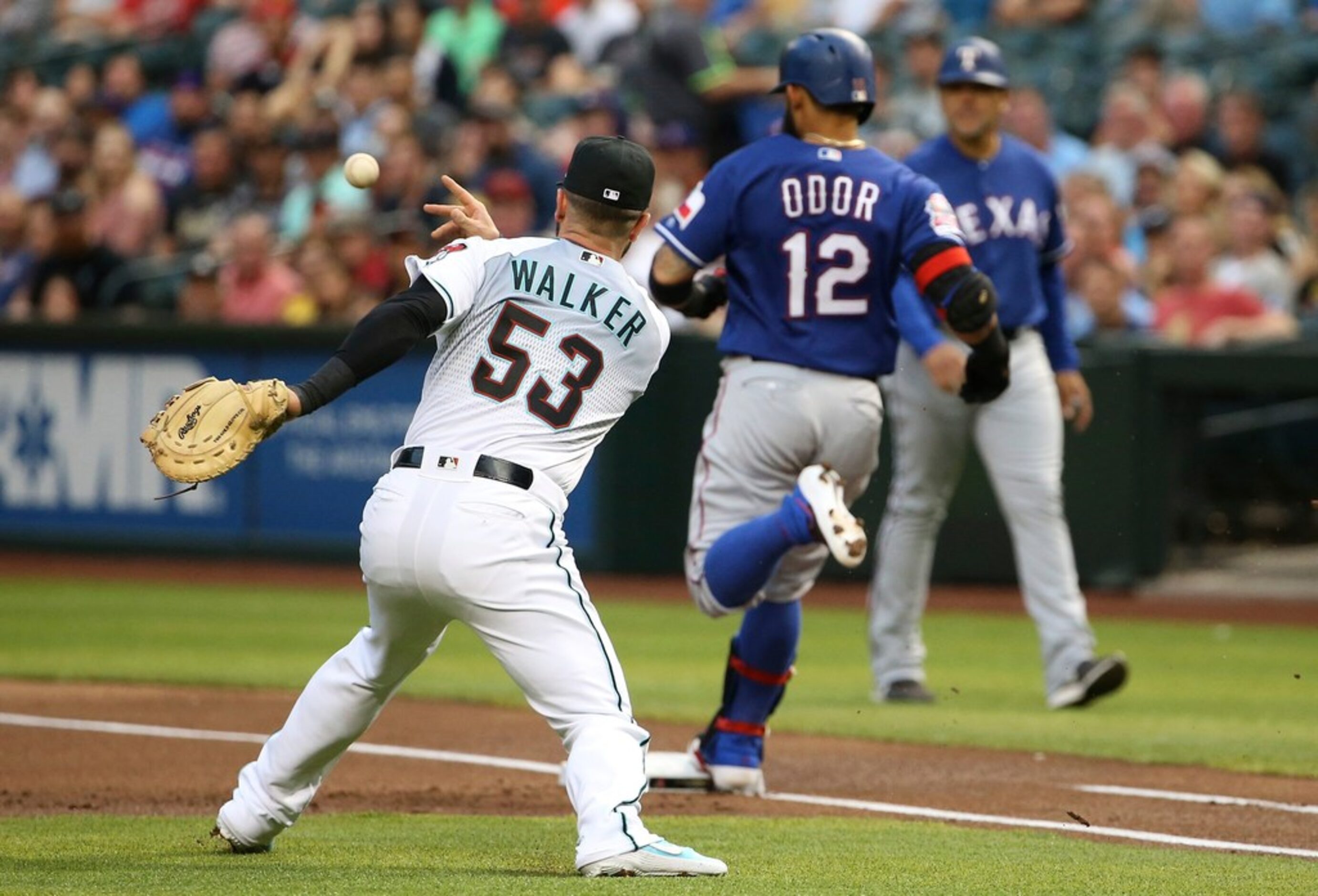 Texas Rangers' Rougned Odor (12) beats out an infield single on a bunt as Arizona...