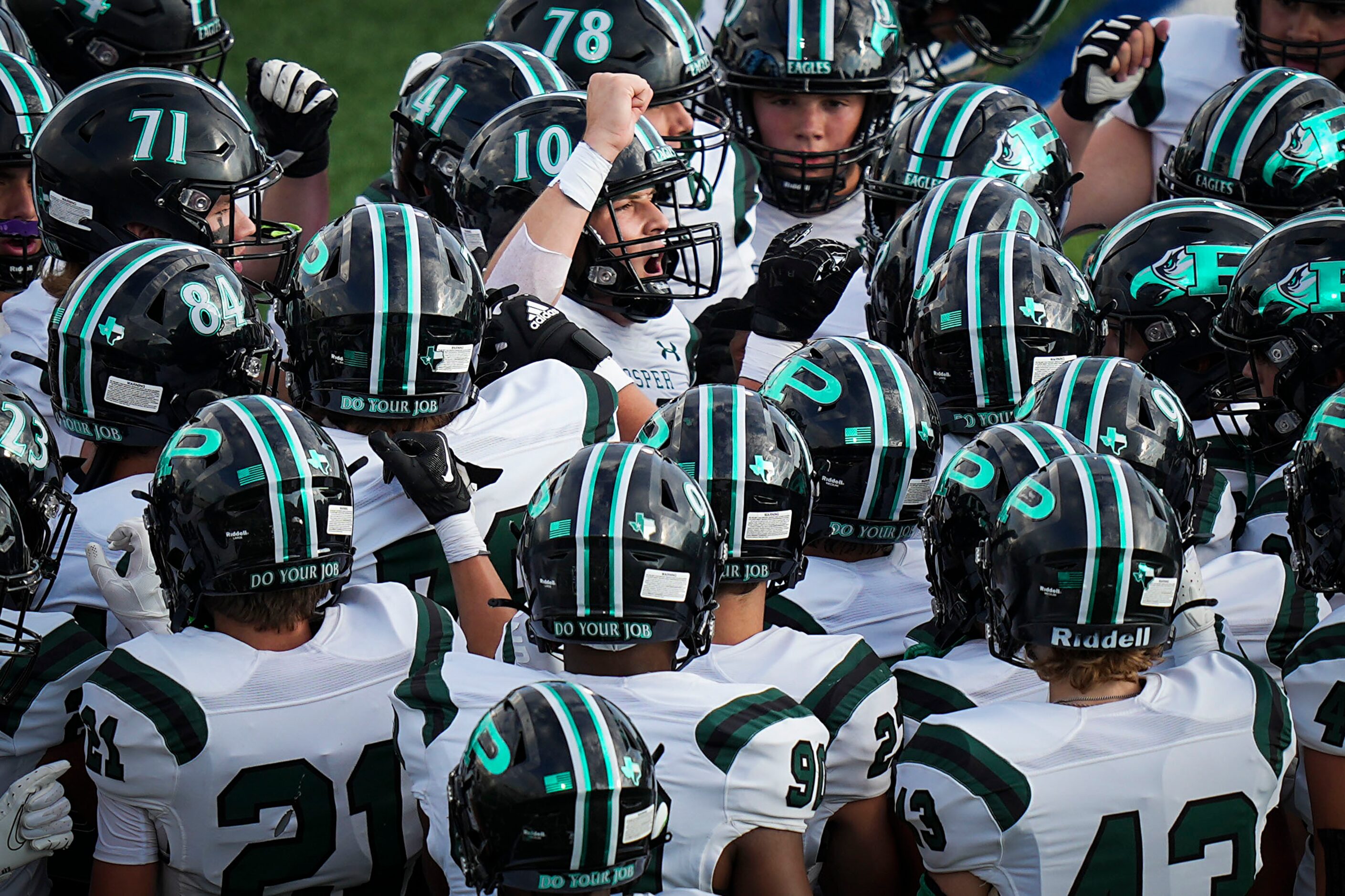 Prosper players huddle around quarterback  Harrison Rosar (10) before a season-opening high...