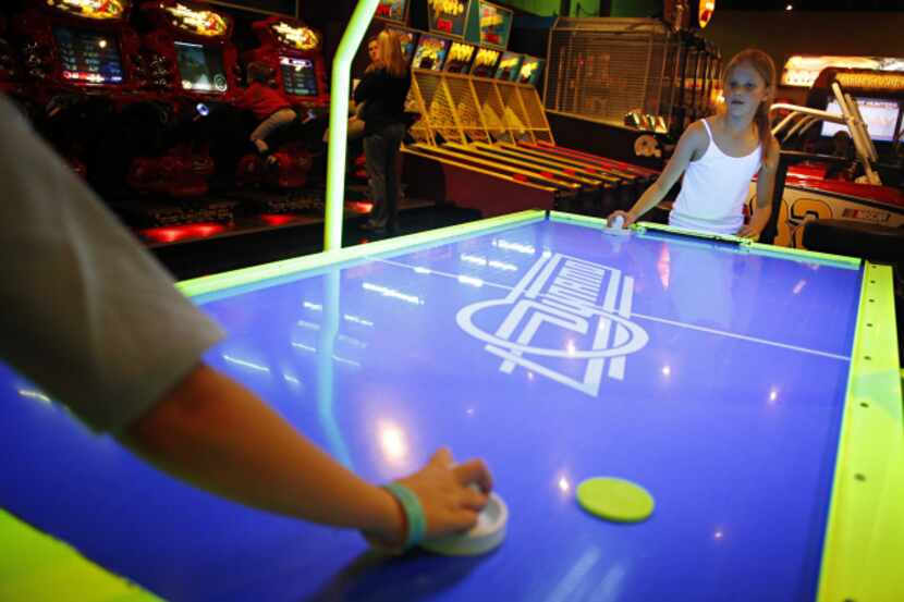 Allison Boyd (right), 9, plays air hockey against her 10-year-old brother, Bobby Boyd, at...