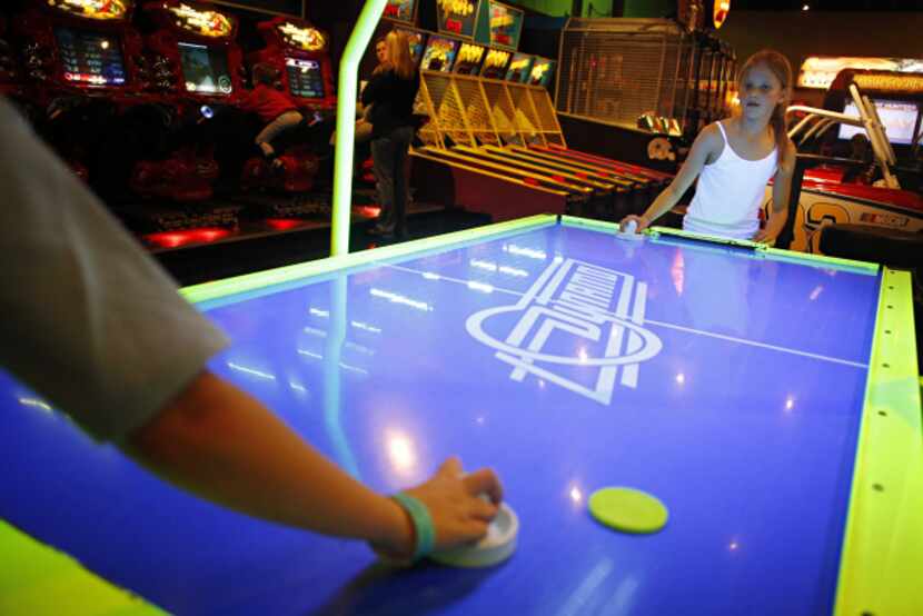 Allison Boyd (right), 9, plays air hockey against her 10-year-old brother, Bobby Boyd, at...