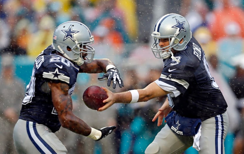 Dallas Cowboys quarterback Tony Romo (9) makes a handoff to running back Darren McFadden...