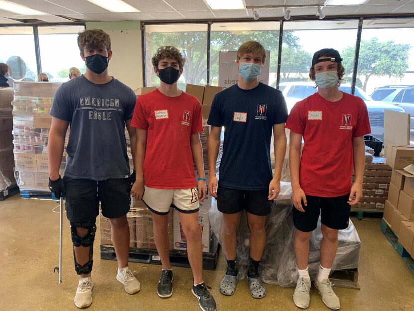 Four teenage boys who are members of Young Men’s Service League stop for a photo while...