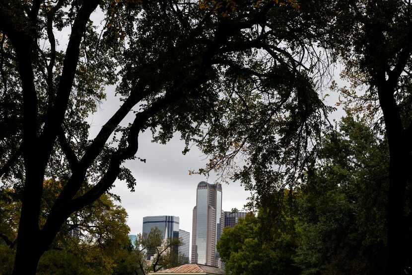 The downtown skyline looms over an old school house at Dallas Heritage Village at Old City...
