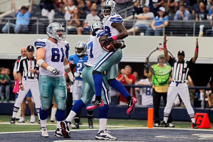 Dallas Cowboys tackle Tyron Smith (77) lifts receiver Dez Bryant into the air after his...