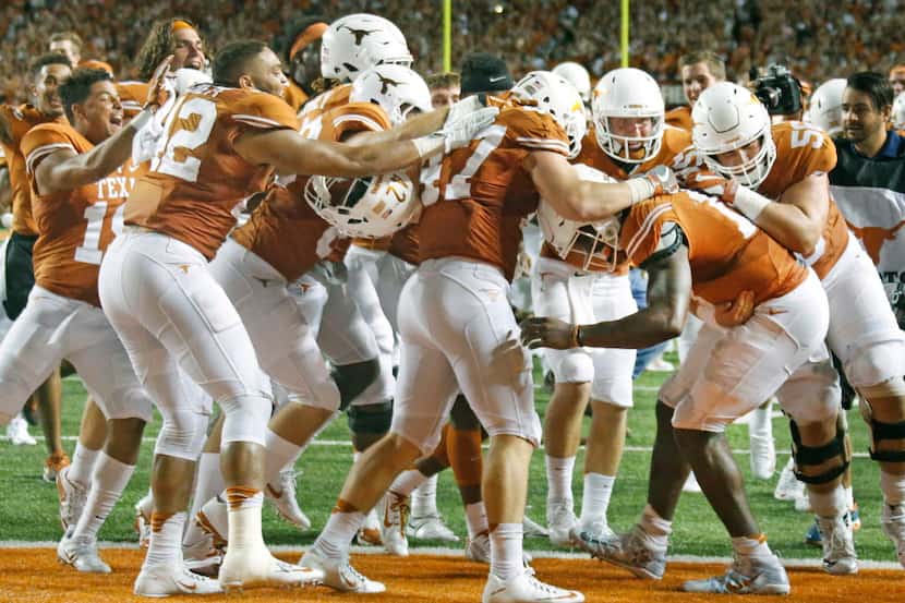 Teammates mob Texas quarterback Tyrone Swoopes after he scored the winning touchdown in the...